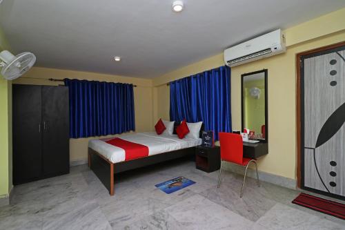 OYO Hotel O Maa Tara Guest House في Jādabpur: غرفة نوم بها سرير ومكتب وتلفزيون
