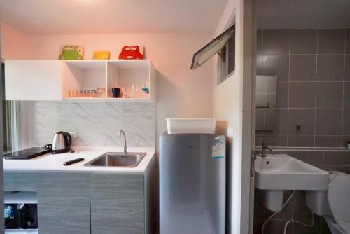 a small kitchen with a sink and a refrigerator at Valley Mountain View&City Proximity Golden Eight Apartment in Ban Phlu Yai