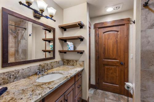 布雷肯里奇Mountain View Penthouse Condo with Loft, Pool, and Hot Tub的一间带水槽和木门的浴室