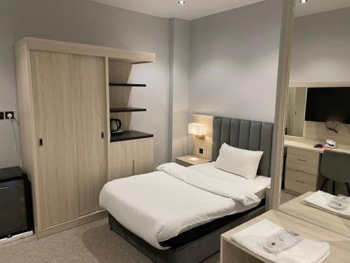 een hotelkamer met twee bedden en een televisie bij Bunyan Alula Hotel in Al Ula