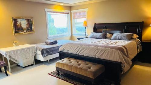 a bedroom with two beds and a chair and a window at Warm house1 in Coquitlam