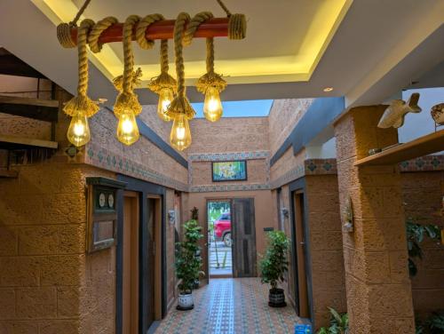 a hallway of a building with lights hanging from the ceiling at Aura Kabini by Tripture in Begūr