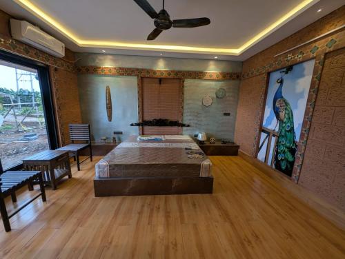 a bedroom with a bed and a ceiling fan at Aura Kabini by Tripture in Begūr