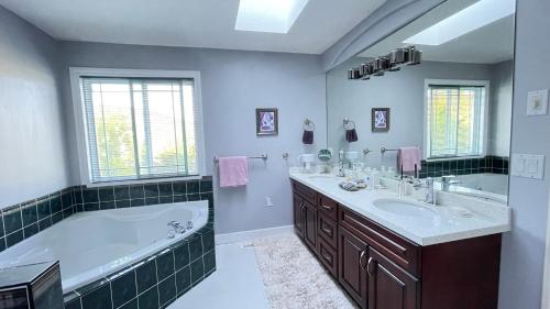 un bagno con una grande vasca e un lavandino di Warm house a Coquitlam