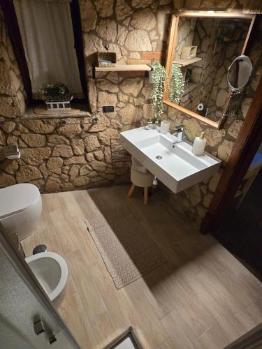 a stone bathroom with a sink and a toilet at Tenuta Oliva in Fisciano