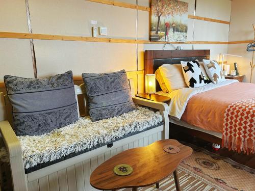 Schlafzimmer mit einem Bett mit Kissen und einem Tisch in der Unterkunft The Cabin in the Woods in Dublin