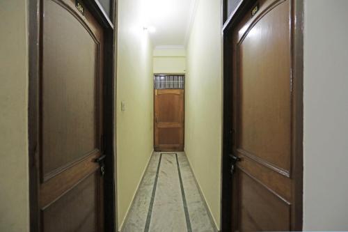 Un pasillo con dos juegos de puertas y un pasillo con un pasillo. en Hotel O Shikhar Paradise, en Gomti Nagar