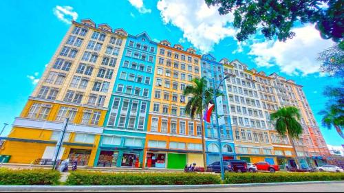 Un gran edificio con palmeras delante. en J&A Cozy Calm Stay, en Biñan