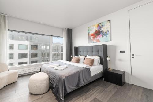 a bedroom with a large bed and a chair at Unbeatable Central Location - Reykjavíks Most Exclusive Luxury Apartments in Reykjavík
