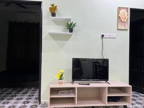 a tv sitting on a table in a room at Inara Homestay in Kepala Batas