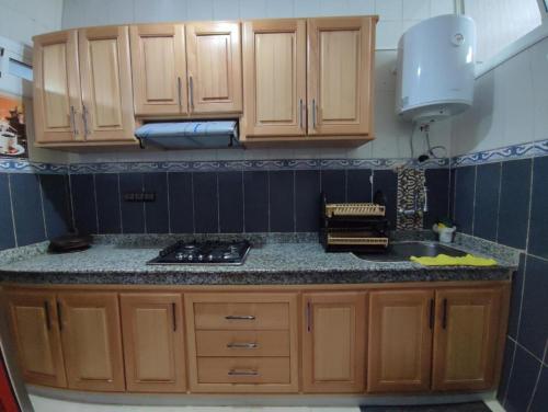 a kitchen with wooden cabinets and a counter top at Dar NABIL in Chefchaouene