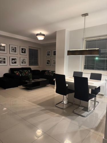 een woonkamer met een tafel, stoelen en een bank bij Spanko w centrum in Zielona Góra