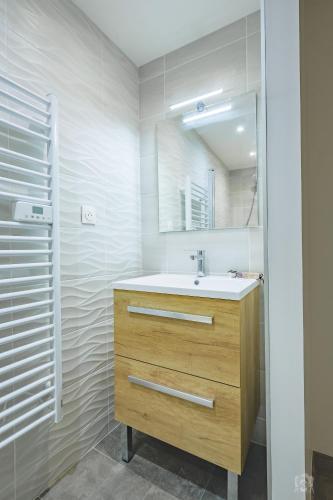 a bathroom with a sink and a mirror at Résidence La Mayt in Vars
