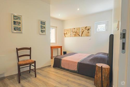 a bedroom with a bed and a chair at Résidence La Mayt in Vars