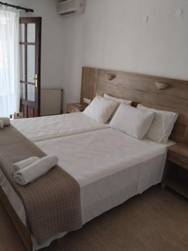 a bedroom with a large bed with white sheets and pillows at Makedonia in Potos