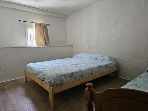 a bedroom with a bed and a window at La Mocha Casa Rural - La Casa de María in La Iruela