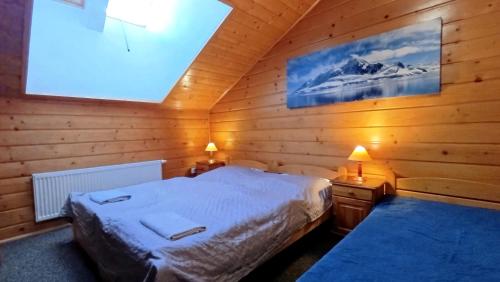ヴィスワにあるWiślany Rajの木製の部屋にベッド1台が備わるベッドルーム1室があります。