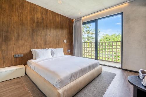 MODERN AND COMFORTABLE JUNGLE VISTA HOTEL Ubud Bali By JV with a relaxing atmosphere في أوبود: غرفة نوم بسرير كبير ونافذة كبيرة