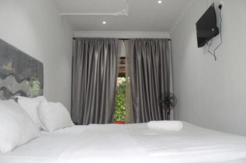 卢萨卡Honeybed Lodge的一间卧室设有两张白色的床和窗户