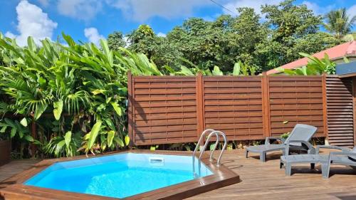 Location saisonnière في بيتي-بور: حديقة خلفية بها مسبح وسياج خشبي