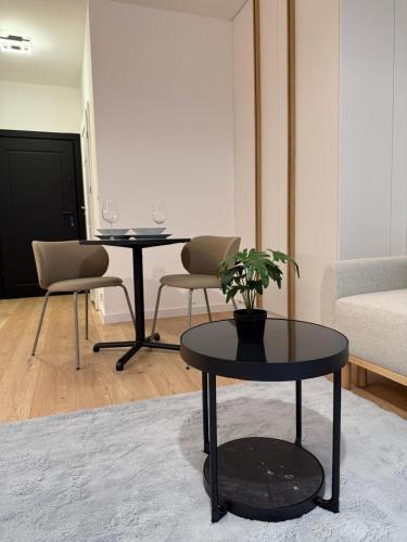 un soggiorno con 2 tavoli e una pianta in vaso di Old Town Bulwar Apartment a Elblag