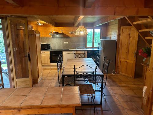 Una cocina con una mesa y sillas de madera en una habitación. en Chalet de l empereur, en Ussel