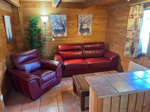 sala de estar con muebles de cuero y mesa en Chalet de l empereur, en Ussel