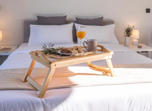 bandeja de comida y copa de vino en la cama en IRIS Garden Rooms, en Kórinthos
