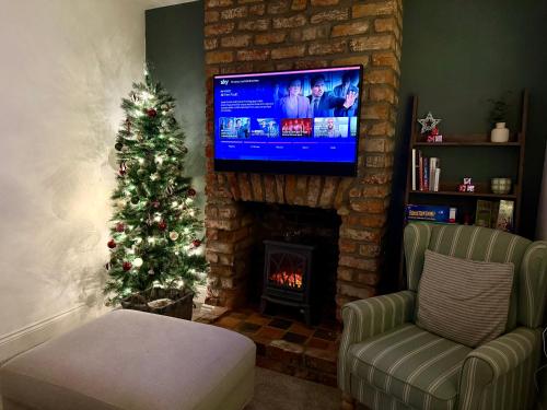 a living room with a christmas tree and a fireplace at The Cottage - Cosy Filey Home in Filey