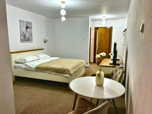 a hotel room with a bed and a table at Montana Inn Slănic Moldova in Slănic-Moldova