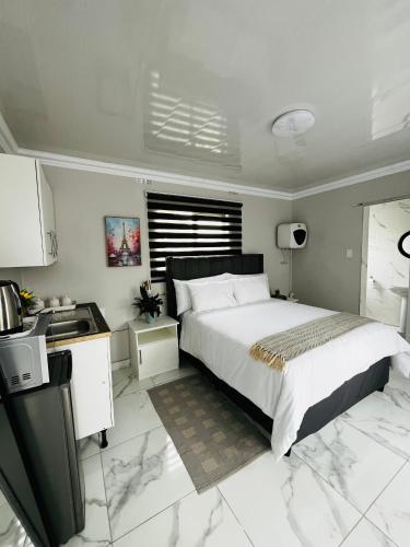 4 at Granada في شرق لندن: غرفة نوم مع سرير كبير ومطبخ