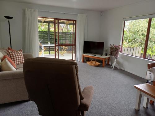 a living room with a couch and a television at House in Restful Setting in Whangarei