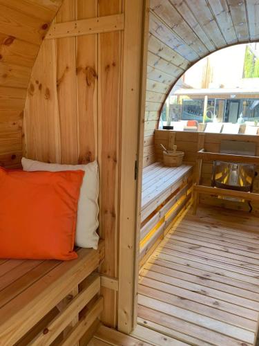 an inside view of a wooden sauna with an orange pillow at Duplex 7 avec Spa Privé in Herstal