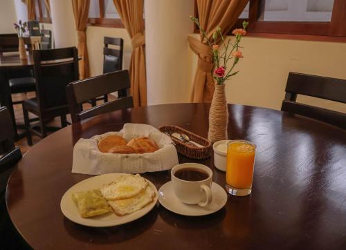 una mesa con desayuno de pan y zumo de naranja en Amazon Luxury, en Chachapoyas