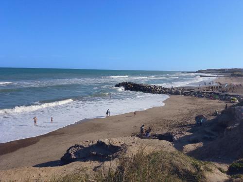 a group of people on a beach near the ocean at AmoVertecasadeveraneo in Colonia Chapadmalal