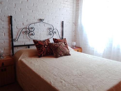 a bed with two pillows on it in a bedroom at AmoVertecasadeveraneo in Colonia Chapadmalal