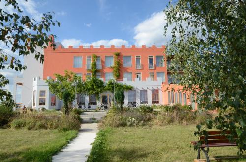 a building in the middle of a park with a bench at Penzion Folbr in Dlouhá Lhota