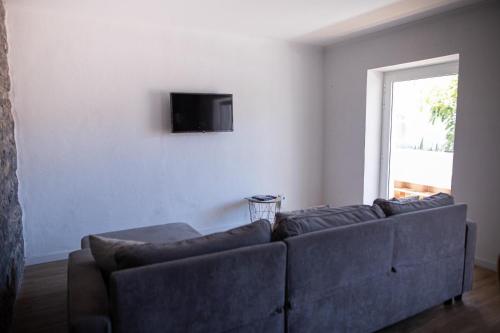 uma sala de estar com um sofá e uma TV na parede em spot do vale em Machico