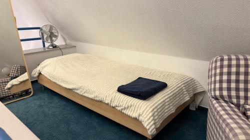 a small bedroom with a bed with a blue towel on it at Elbträume Lodge in Ellerhoop