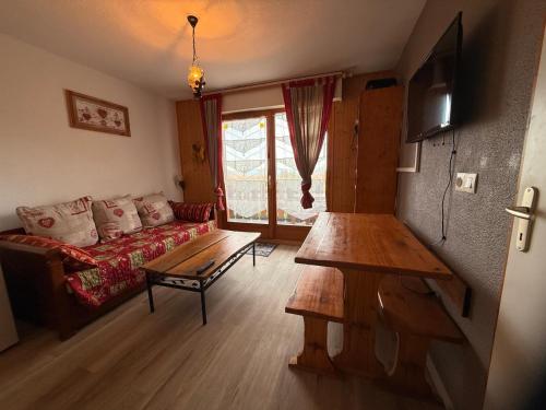 apptT2 station ski familiale في تولو: غرفة معيشة مع أريكة وطاولة