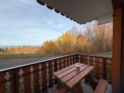 apptT2 station ski familiale في تولو: طاولة خشبية على شرفة مع كوب من القهوة