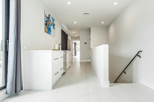 劳德代尔堡Luxury Paradise walk to Las Olas -5 mins to Beach的白色的厨房,配有白色的橱柜和走廊