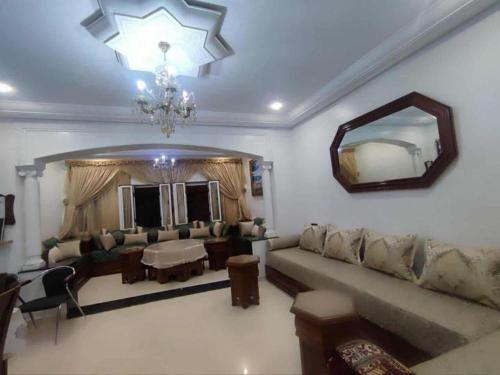 a living room with a couch and a mirror at Dar NABIL in Chefchaouene