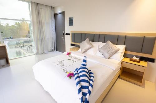 a bedroom with a large white bed with flowers on it at Aqua Luna Dhangethi in Dhangethi