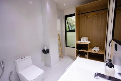 a bathroom with a toilet and a window at Aqua Luna Dhangethi in Dhangethi
