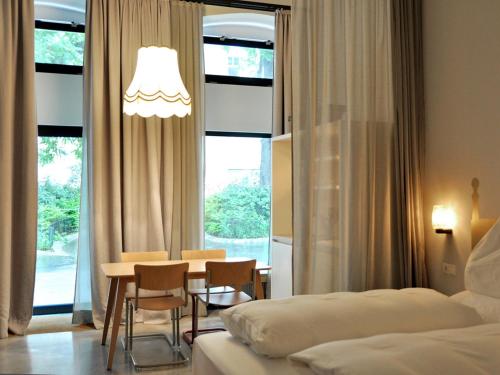 
a room with a table, chairs, lamps and a lamp post at Graetzlhotel Karmelitermarkt in Vienna
