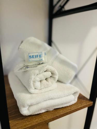 a pile of towels sitting on a wooden shelf at Hotel Westend in Cologne