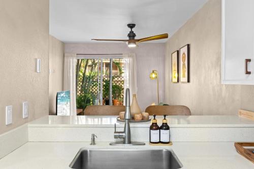 a kitchen with a sink and two bottles of wine at Casa Aloha Designer Condo w Oceanfront Pool in Kailua-Kona