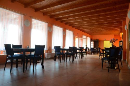 a dining room with tables and chairs and windows at Penzion Folbr in Dlouhá Lhota