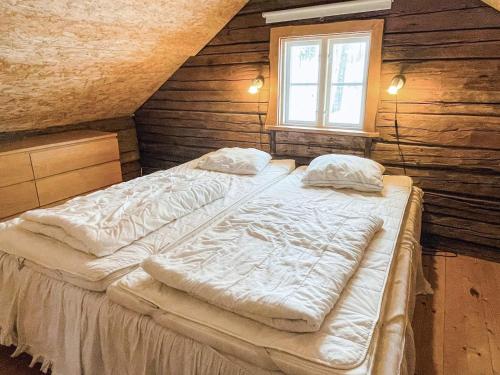 2 letti in una camera con pareti in legno e finestra di 5 person holiday home in ÅSEDA a Åseda